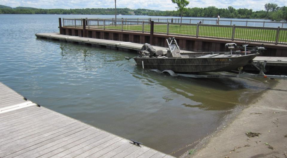 A boat launch with one boat going into the water.