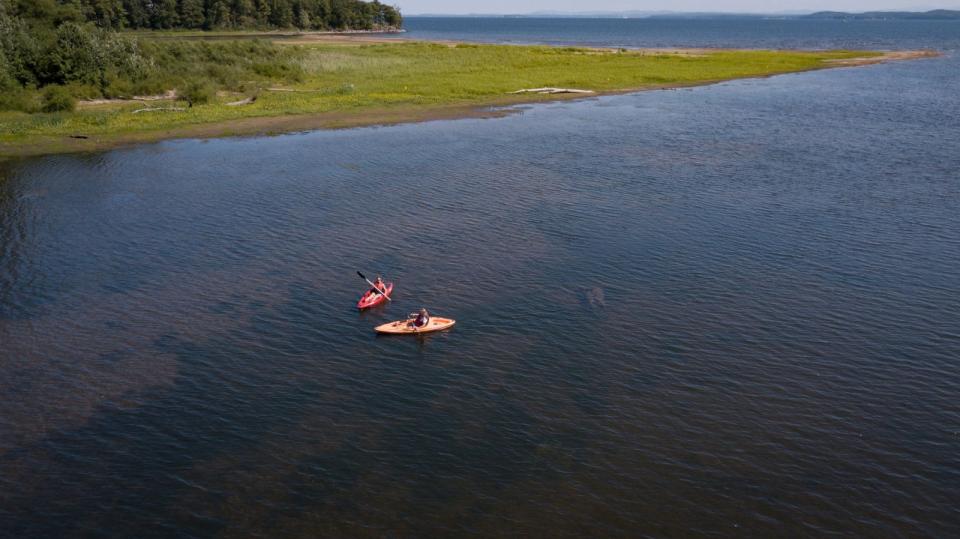 Two kayakers paddling at Noblewood Park with Lake Champlain in the background.