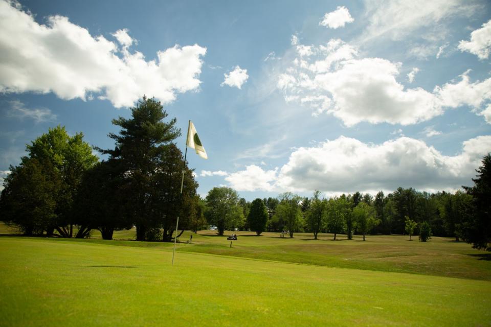 A bright green with blue sky and light clouds at the Westport Golf Club.