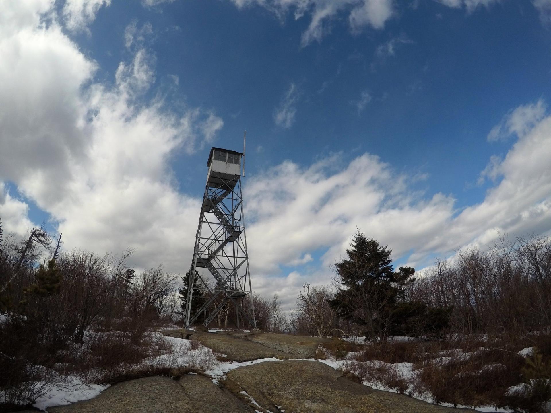 A tall steel firetower on a mountain