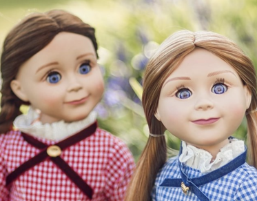 Two american girl dolls.