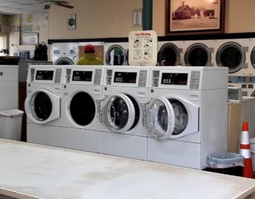 A long line of white washing machines.