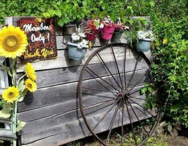A wooden fence with flower planters hanging from the top with a sign reading members only