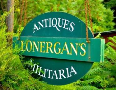 A green hanging sign reading Antiques Lonergan's Militaria