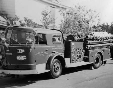 A black and white photo of an older fire truck.