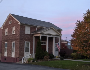 A large brick structure with white trim and large columns.