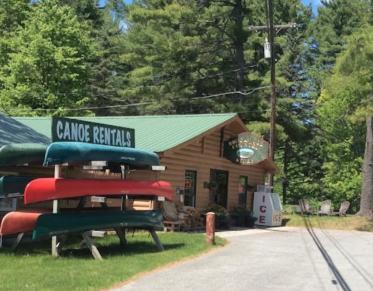 A log structure with a rack for canoes out front.