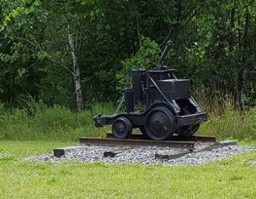 An old mine cart on display outdoors.