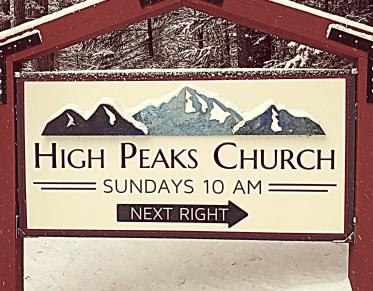 A sign for the entry to High Peaks Church blanketed in light snow