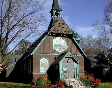 A small brown church with mint green trim.