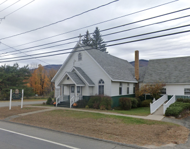 Roadside view of the quaint white church entrance.