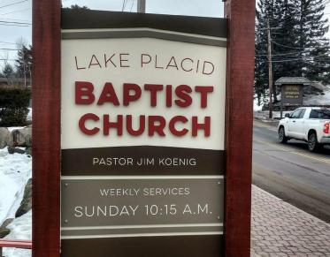 The brown sign with white background for the Lake Placid Baptist Church