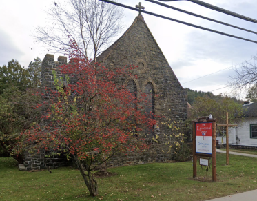 An old stone church with a flowering tree