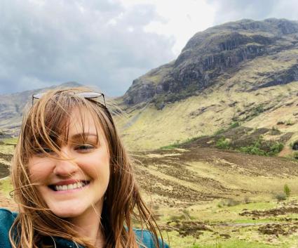 A selfie of a woman with a scenic background.