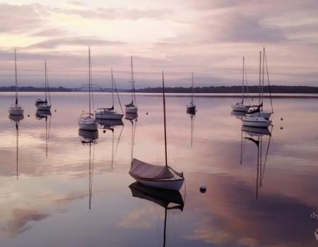 moored sailboats agains pink evening sky