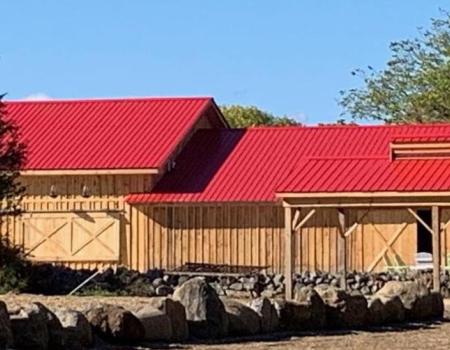 A wooden barn with red metal roof.