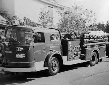A black and white photo of an older fire truck.