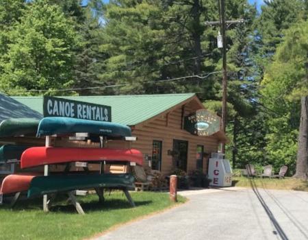 A log structure with a rack for canoes out front.