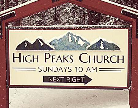 A sign for the entry to High Peaks Church blanketed in light snow