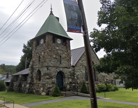 A green patina on the steeple of this stacked river stone church