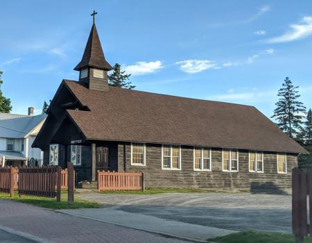 Exterior view of the log building housing Pilgrim Holiness Church in lake placid