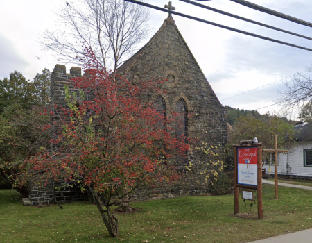 An old stone church with a flowering tree