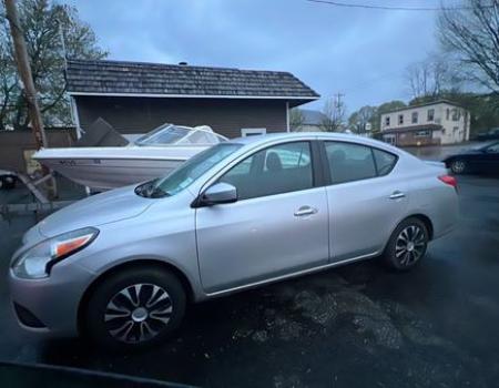 A silver 2019 Nissan Versa available for taxi rides