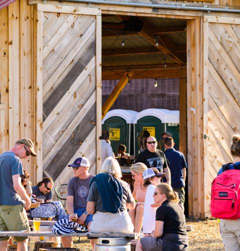 A group of people enjoy beer at a barn-themed brewery. 