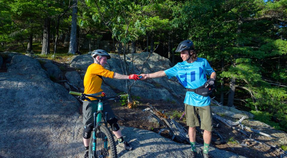 Two mountain bikers fist bump
