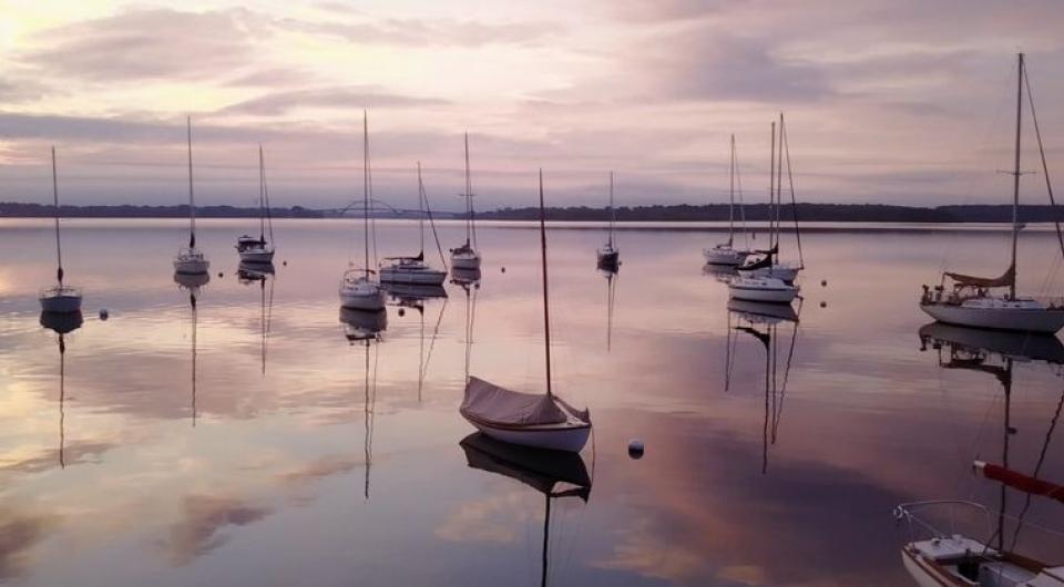 moored sailboats agains pink evening sky