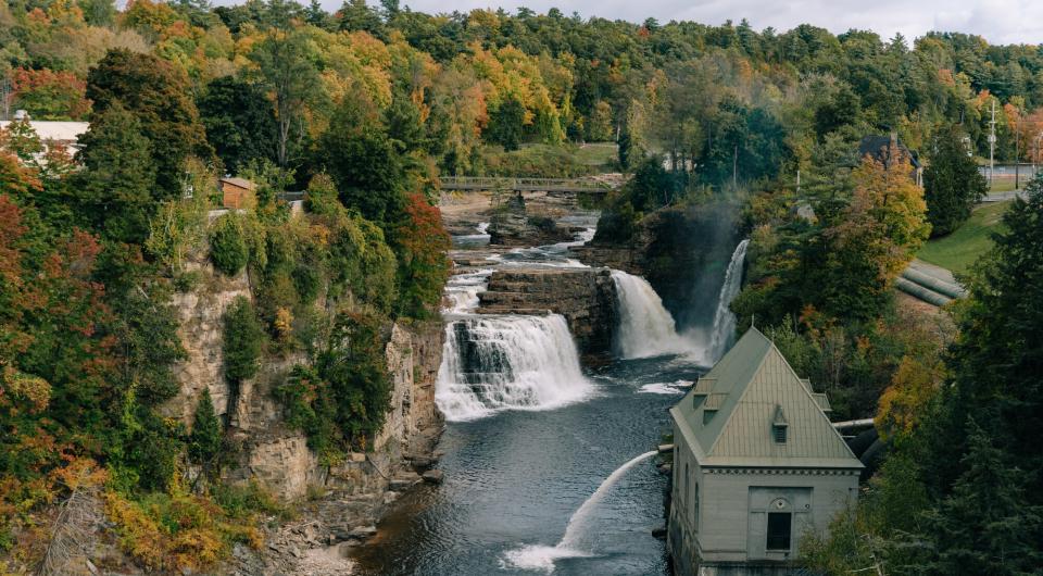 Water crashes over the falls with a building near by