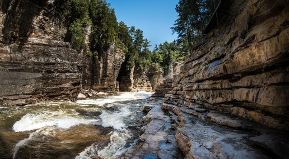 A view of the water rushing past with the towering walls of the gorge surrounding you