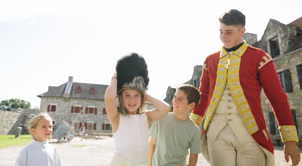 Kid in period garb smiles at camera