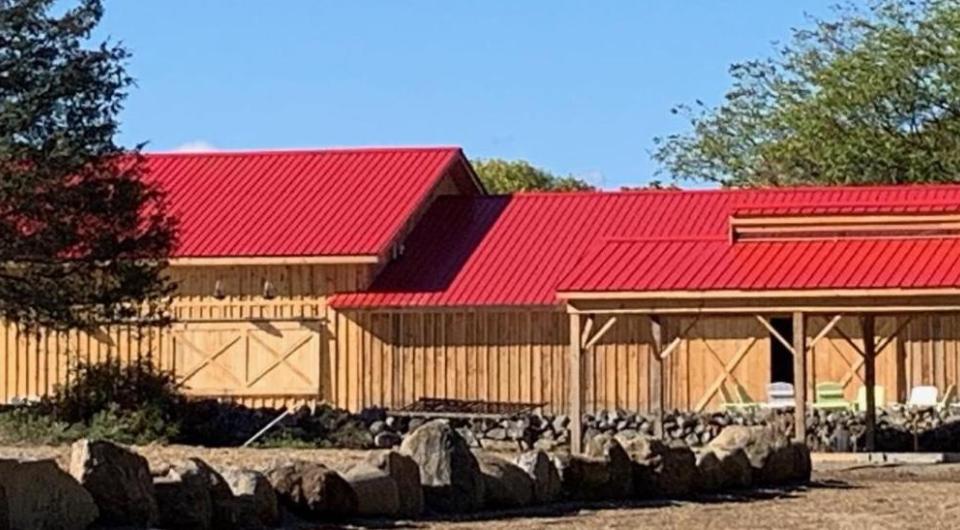 A wooden barn with red metal roof.