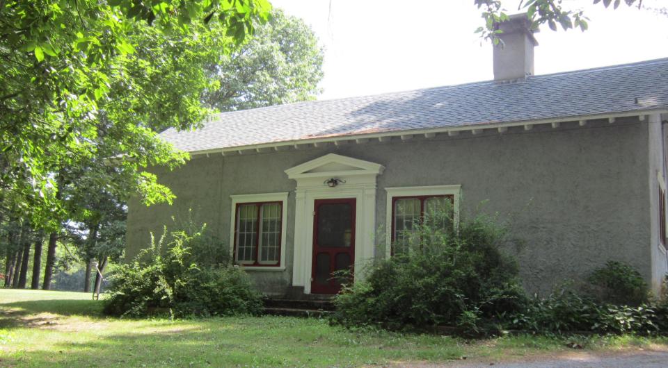 A small green structure with white trim.