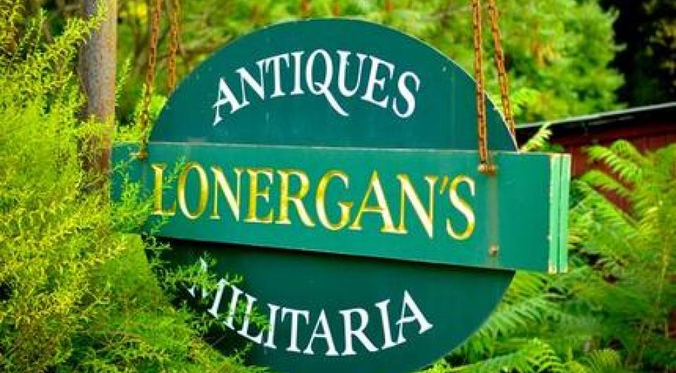 A green hanging sign reading Antiques Lonergan's Militaria