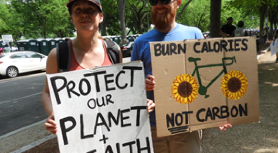 People holding signs petitioning for protection of our planet.