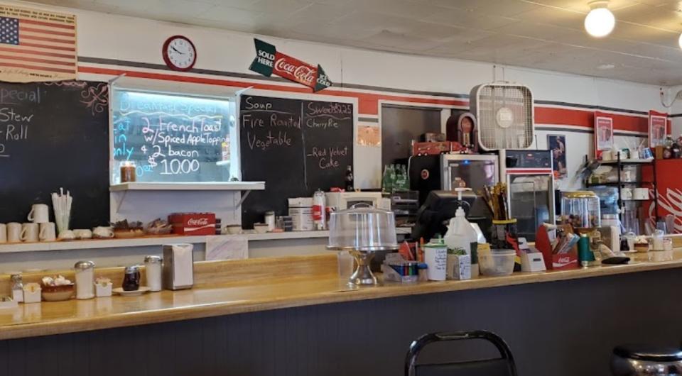 The diner bar with chalkboard with specials behind.