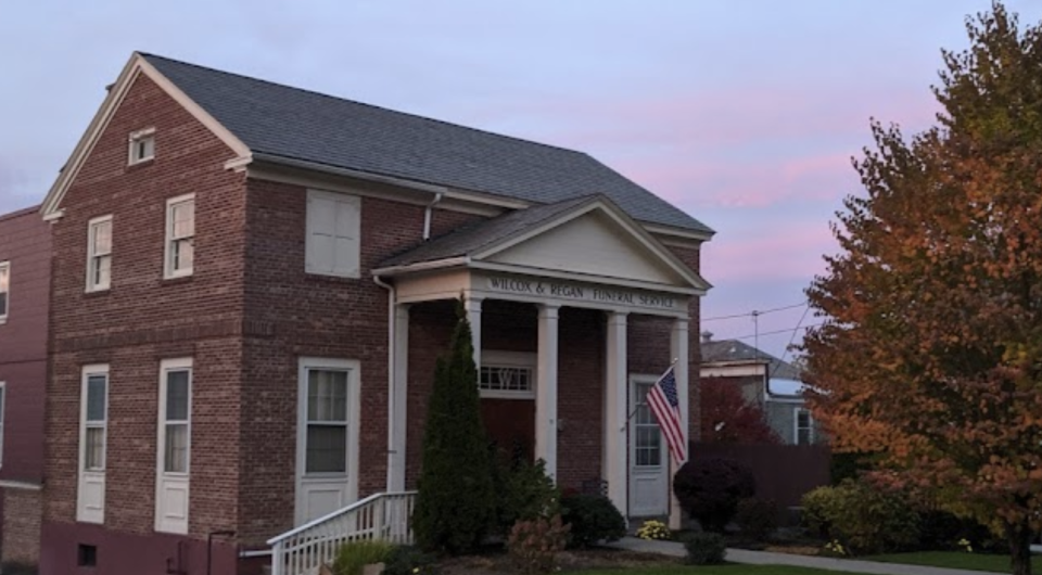 A large brick structure with white trim and large columns.