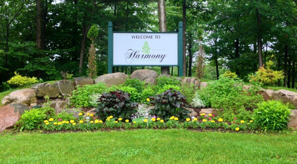 The front entry sign for Harmony Golf Club & Community with landscaping surrounding.