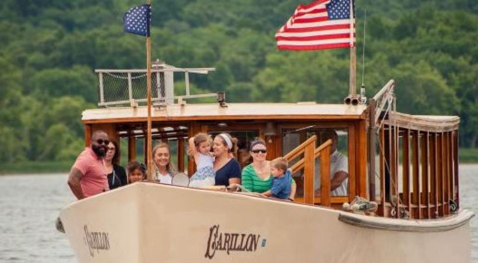 People stand on the bow of the Carillon during their cruise.