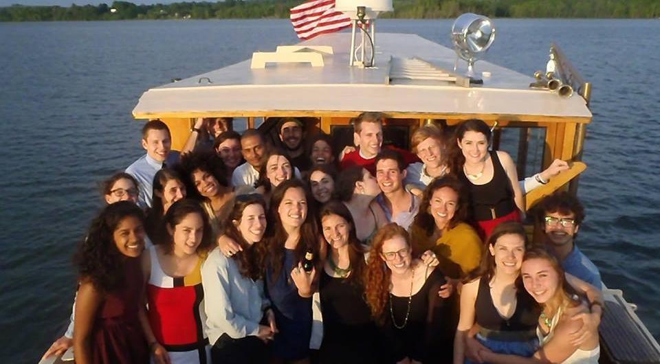A group of nicely dressed young people stand together on the back of the Carillon