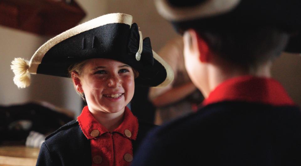 Kids dressed up in period clothing smiling