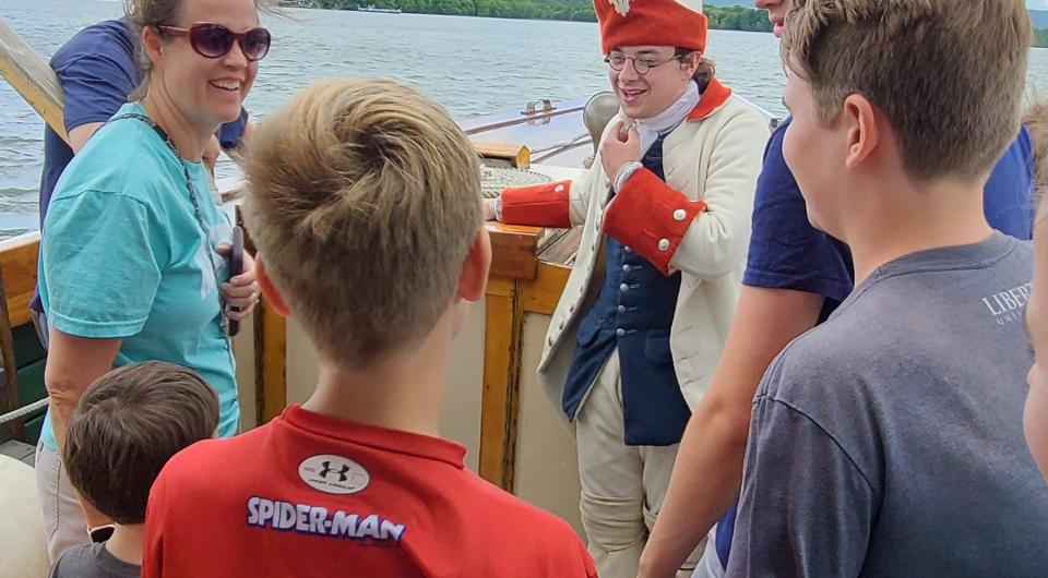 The captain of the Carillon speaks to the public aboard the boat cruise.