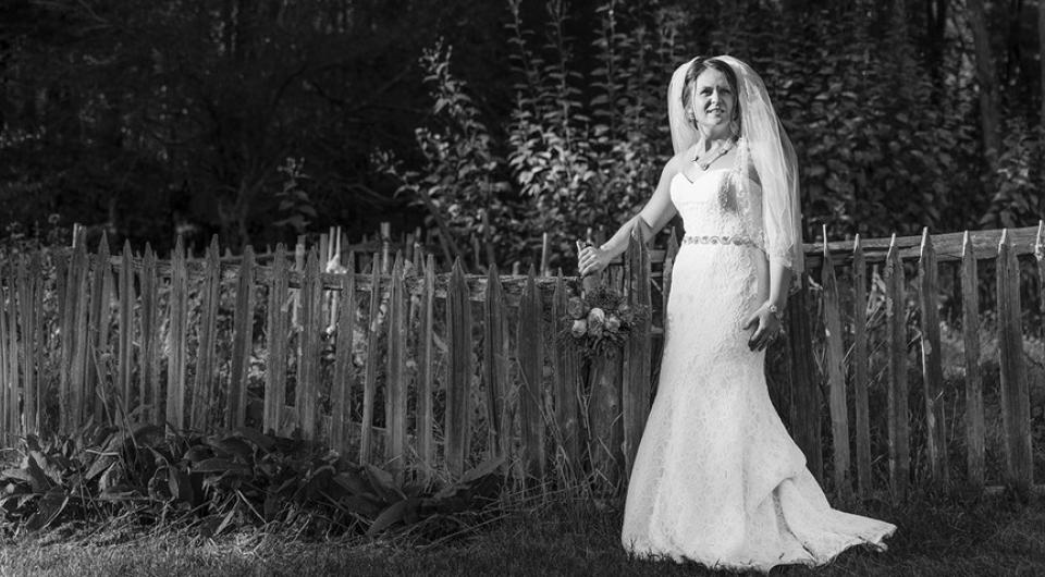 Bride and groom exchange a kiss by a lake.