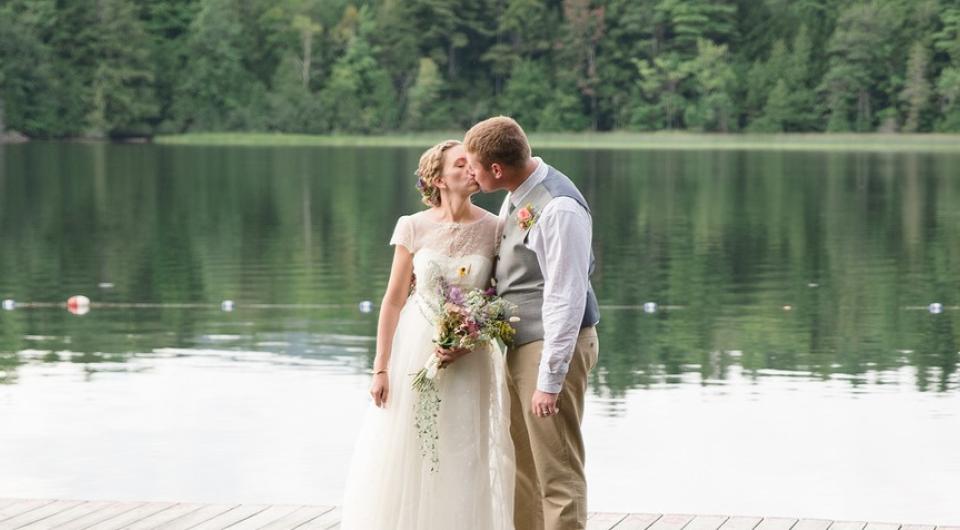  flower girl and ring bearer sit by a boulder.