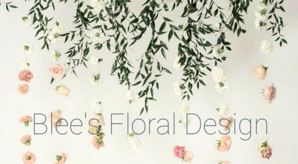 Flowers dangle by a wall over Blee's Floral Design.