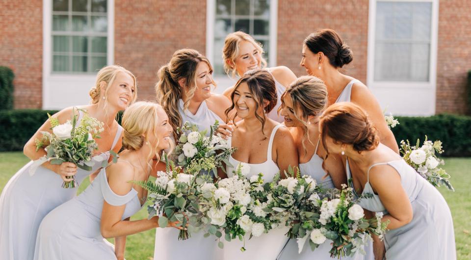 Bridesmaids holding white bouquets.