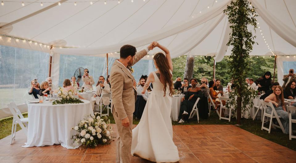 Bride and groom dance under a white tent