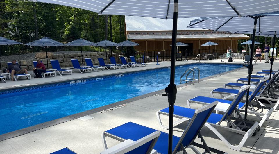 Blue sun chairs under sun umbrellas by the pool.